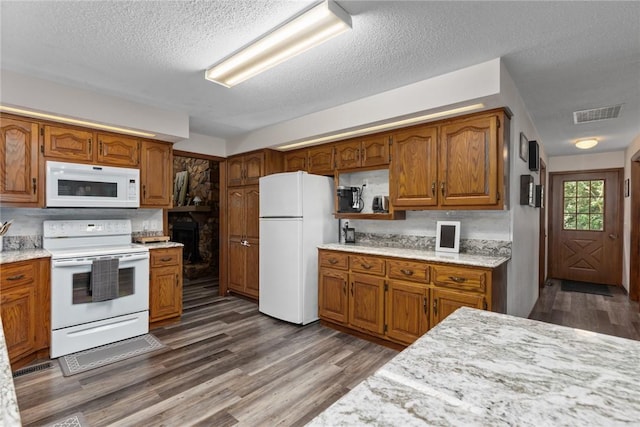 18058 E 1545th Ave, Teutopolis, IL 62467 - kitchen featuring white appliances, wood finished floors, brown cabinets, a textured ceiling, and light stone counters