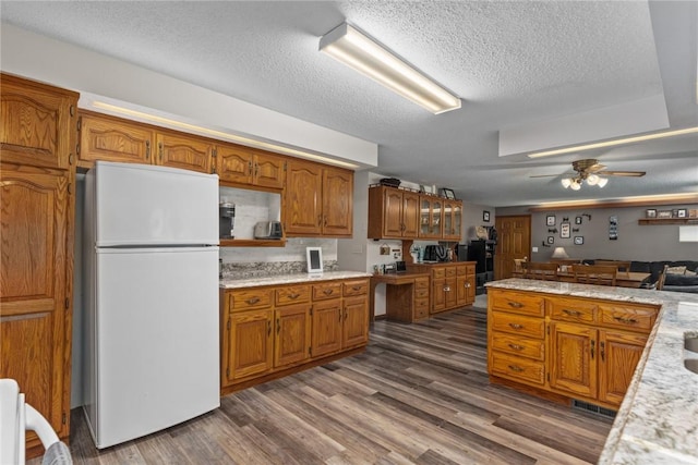 18058 E 1545th Ave, Teutopolis, IL 62467 - kitchen with freestanding refrigerator, brown cabinets, light countertops, a textured ceiling, and a ceiling fan