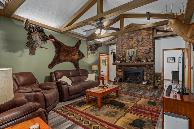 18058 E 1545th Ave, Teutopolis, IL 62467 - living room with ceiling fan, beam ceiling, wood finished floors, a fireplace, and a textured ceiling