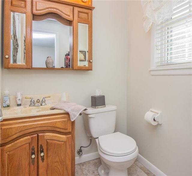 bathroom with tile patterned floors, toilet, vanity, and baseboards