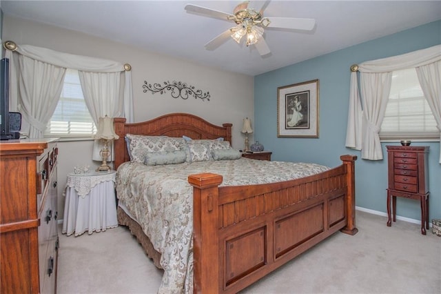 bedroom featuring light carpet, baseboards, and a ceiling fan