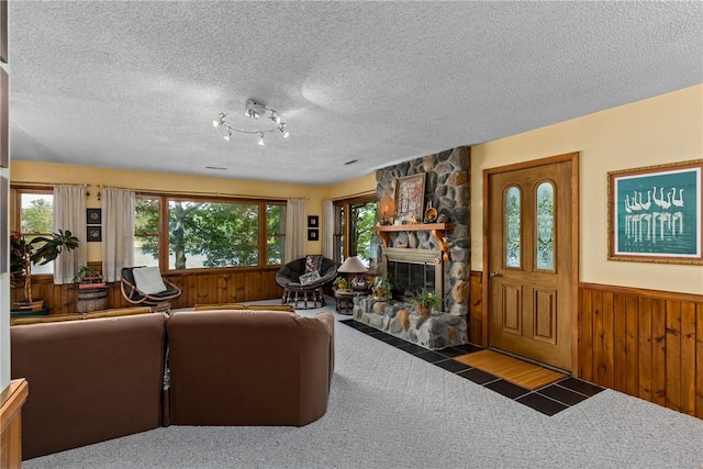 14915 N 8th Ave, Effingham, IL 62401 - carpeted living area featuring wood walls, a wainscoted wall, a stone fireplace, and a textured ceiling