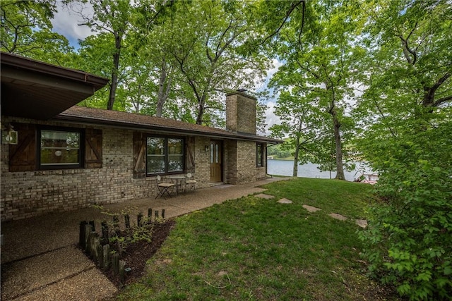 14915 N 8th Ave, Effingham, IL 62401 - rear view of property featuring a chimney, a lawn, brick siding, a water view, and a patio area