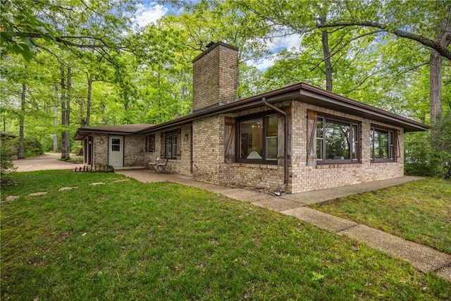 14915 N 8th Ave, Effingham, IL 62401 - view of home's exterior featuring a chimney, a patio area, a lawn, and brick siding
