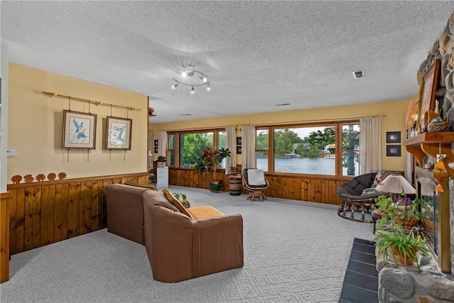 14915 N 8th Ave, Effingham, IL 62401 - carpeted living room featuring wood walls, a wainscoted wall, healthy amount of natural light, a textured ceiling, and a water view