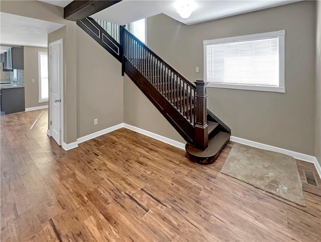 stairs with visible vents, baseboards, and wood finished floors