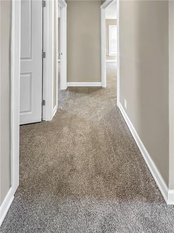 hall featuring carpet floors and baseboards