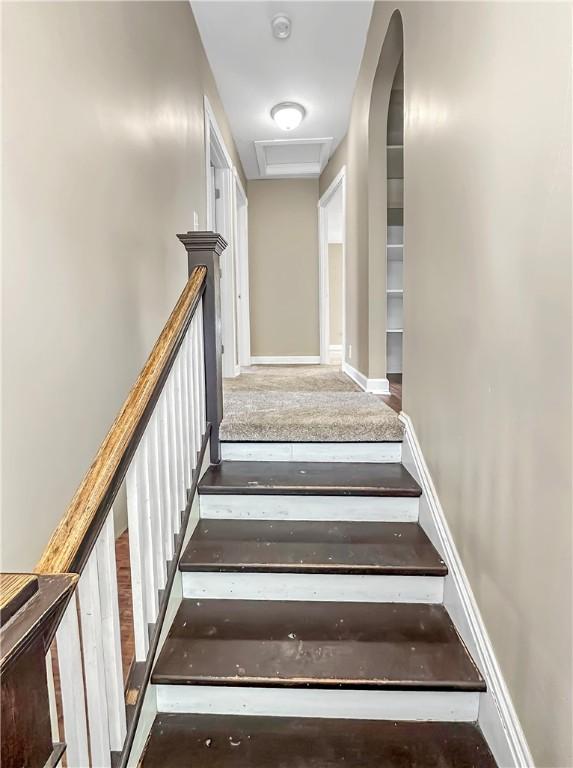 stairway with attic access and baseboards