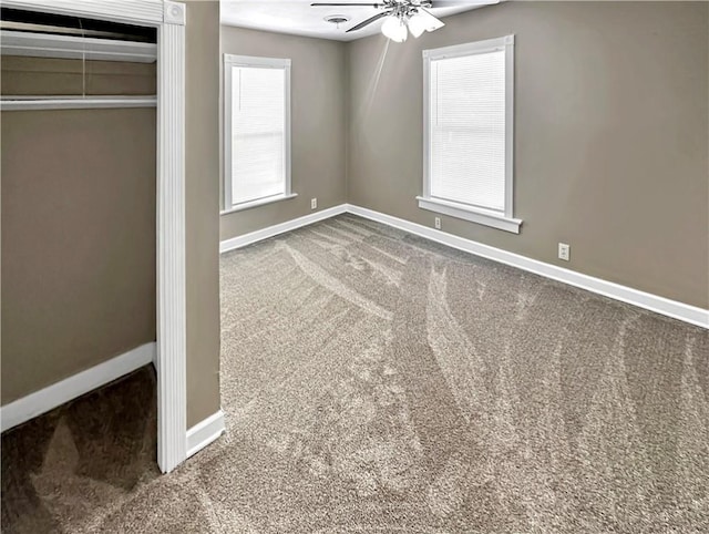 unfurnished bedroom featuring carpet, baseboards, ceiling fan, and a closet