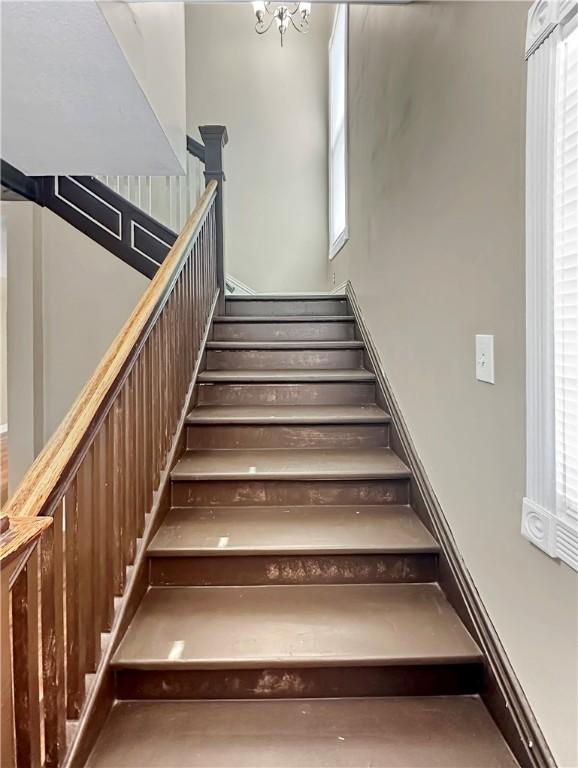 stairs with an inviting chandelier