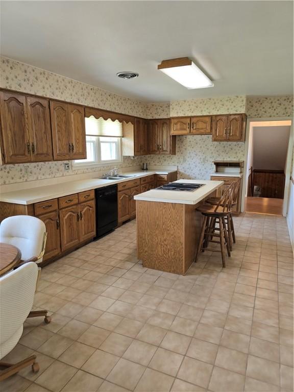 9 Orchard Dr, Charleston, IL 61920 - kitchen with black dishwasher, wallpapered walls, a center island, light countertops, and brown cabinets