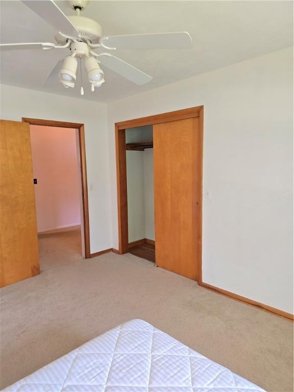 9 Orchard Dr, Charleston, IL 61920 - unfurnished bedroom featuring carpet flooring, a closet, baseboards, and a ceiling fan