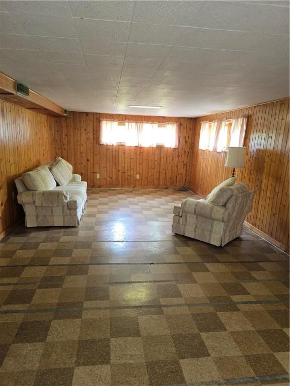 9 Orchard Dr, Charleston, IL 61920 - unfurnished living room featuring dark floors, wooden walls, and plenty of natural light