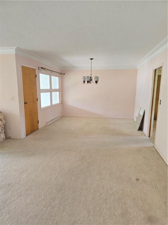 9 Orchard Dr, Charleston, IL 61920 - empty room featuring crown molding, light carpet, and a chandelier