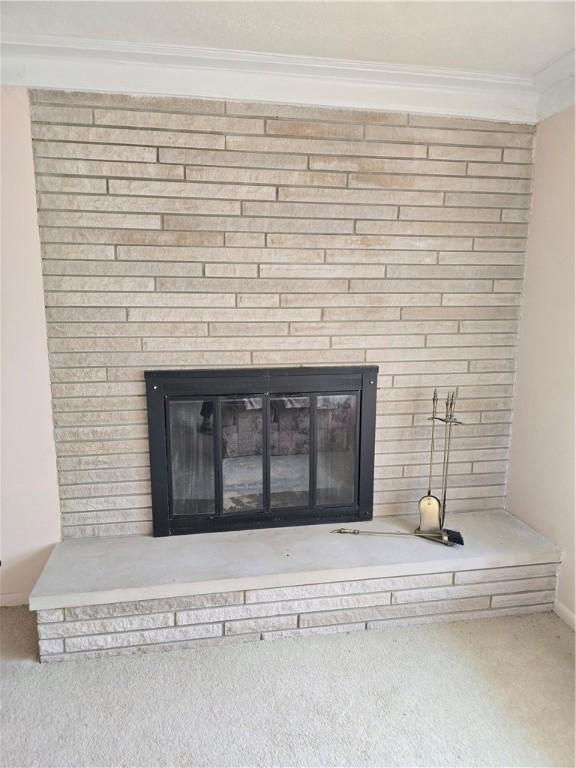 9 Orchard Dr, Charleston, IL 61920 - detailed view of a brick fireplace, crown molding, carpet, and baseboards