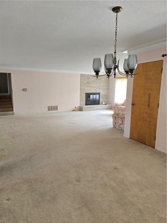 9 Orchard Dr, Charleston, IL 61920 - unfurnished living room featuring a fireplace, crown molding, a chandelier, light colored carpet, and a textured ceiling