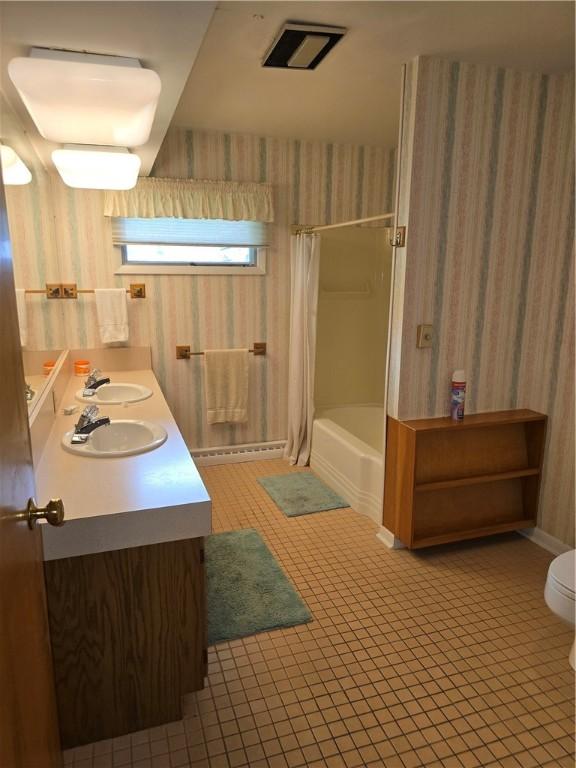 9 Orchard Dr, Charleston, IL 61920 - full bath with wallpapered walls, tile patterned floors, toilet, double vanity, and shower / bath combo with shower curtain