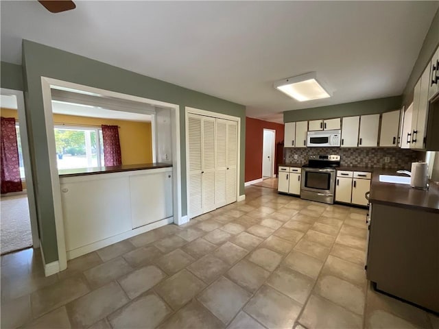 1408 Hickory Hill Dr, Effingham, IL 62401 - kitchen featuring electric stove, dark countertops, white microwave, backsplash, and white cabinetry