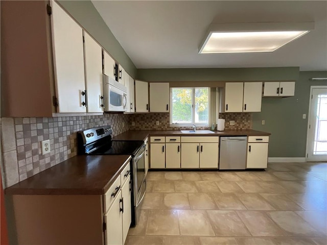 1408 Hickory Hill Dr, Effingham, IL 62401 - kitchen featuring appliances with stainless steel finishes, dark countertops, tasteful backsplash, a sink, and white cabinets