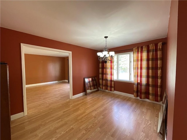 1408 Hickory Hill Dr, Effingham, IL 62401 - unfurnished room with light wood-type flooring, a chandelier, and baseboards