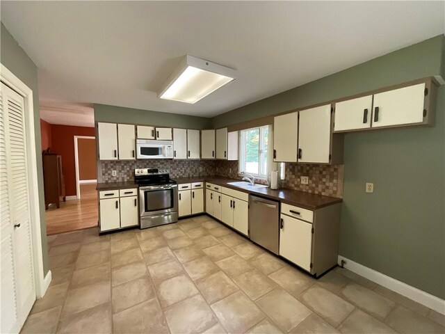 1408 Hickory Hill Dr, Effingham, IL 62401 - kitchen featuring appliances with stainless steel finishes, dark countertops, backsplash, and a sink