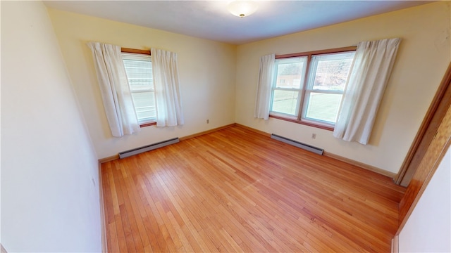 spare room featuring light hardwood / wood-style floors and a baseboard heating unit