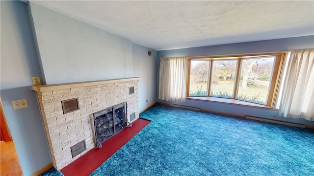 carpeted living room with a fireplace, a textured ceiling, and a baseboard heating unit