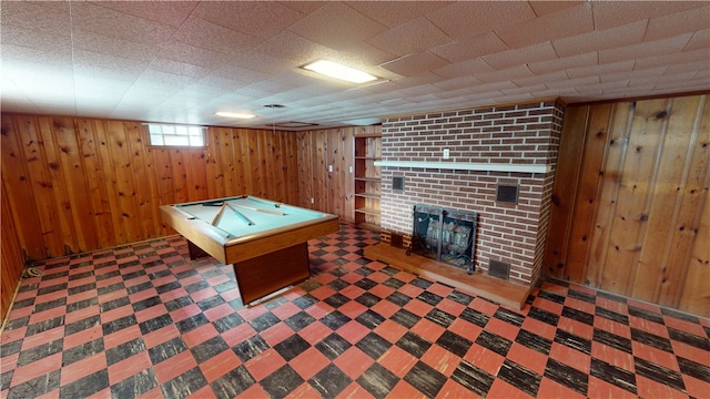 rec room featuring wood walls, billiards, and a brick fireplace