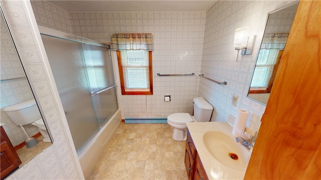 full bathroom with vanity, toilet, enclosed tub / shower combo, baseboard heating, and tile walls