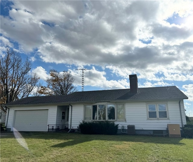 ranch-style home with central AC, a garage, and a front lawn