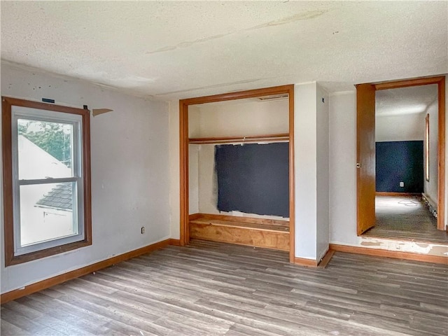 1710 11th St, Charleston, IL 61920 - unfurnished bedroom featuring wood finished floors, a textured ceiling, and a closet