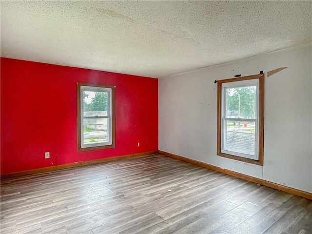 1710 11th St, Charleston, IL 61920 - spare room with healthy amount of natural light, wood finished floors, and a textured ceiling