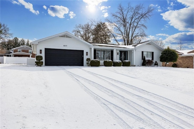 single story home with a garage and fence