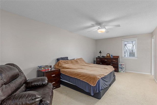 bedroom with a textured ceiling, baseboards, a ceiling fan, and light colored carpet