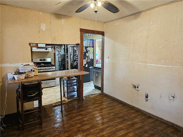 kitchen featuring black fridge, ceiling fan, dark hardwood / wood-style flooring, and stainless steel gas stove