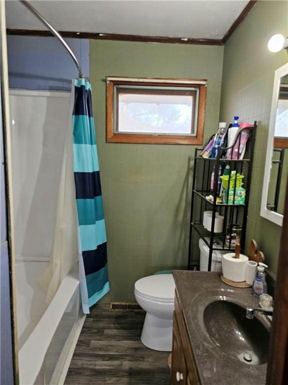 full bathroom featuring vanity, wood-type flooring, ornamental molding, toilet, and shower / bath combo with shower curtain