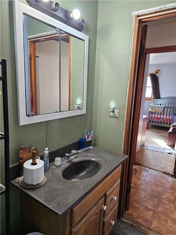 bathroom featuring vanity, parquet floors, and decorative backsplash