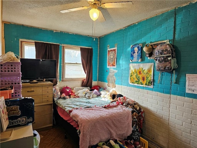 bedroom with brick wall, ceiling fan, parquet flooring, and a textured ceiling