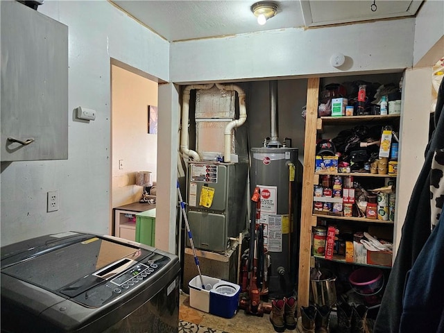 utility room featuring water heater and washer / dryer