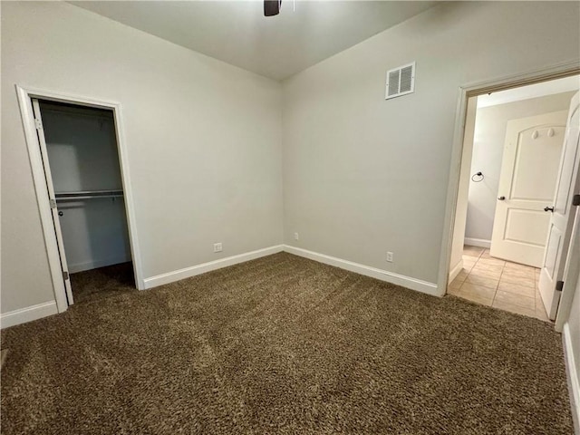 2421 Charleston Ave, Mattoon, IL 61938 - unfurnished bedroom with carpet, a closet, a spacious closet, and a ceiling fan