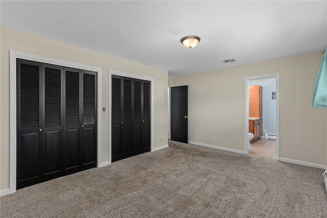 33 Homestead Dr, Newton, IL 62448 - unfurnished bedroom with multiple closets, carpet flooring, baseboard heating, baseboards, and ensuite bathroom