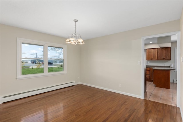 33 Homestead Dr, Newton, IL 62448 - unfurnished dining area featuring a baseboard heating unit, a chandelier, light wood-style flooring, and baseboards