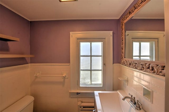 bathroom featuring a wainscoted wall, plenty of natural light, and toilet