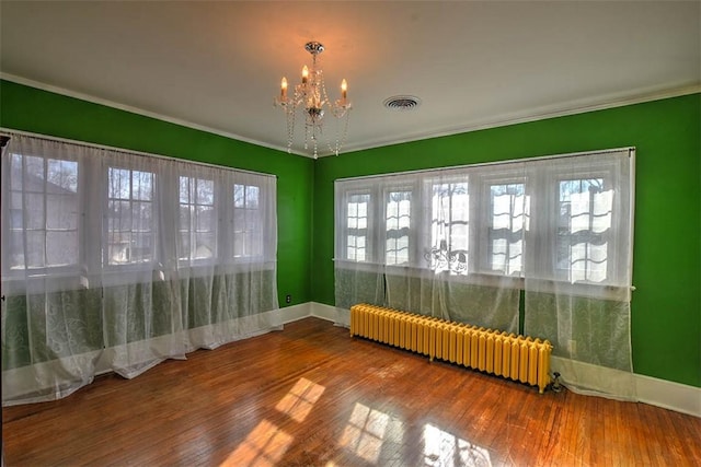 unfurnished sunroom with radiator, an inviting chandelier, and visible vents