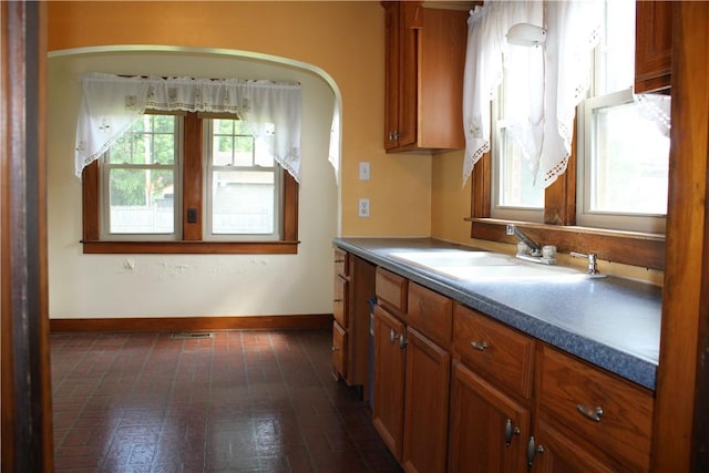 707 W N 2nd St, Shelbyville, IL 62565 - kitchen featuring a sink, brick patterned floors, brown cabinetry, and baseboards