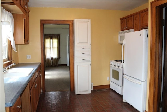 707 W N 2nd St, Shelbyville, IL 62565 - kitchen featuring white appliances, a sink, brick patterned flooring, brown cabinetry, and baseboards