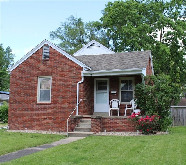 707 W N 2nd St, Shelbyville, IL 62565 - view of front of home featuring a porch, a front lawn, brick siding, and a shingled roof