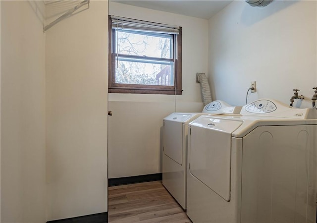 laundry area featuring separate washer and dryer and light wood-type flooring