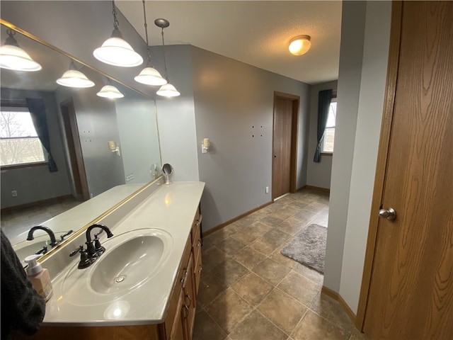 bathroom featuring a wealth of natural light, vanity, and baseboards