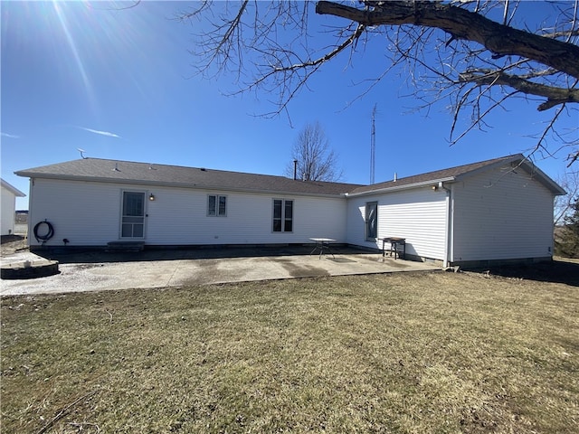 rear view of house with a patio and a lawn